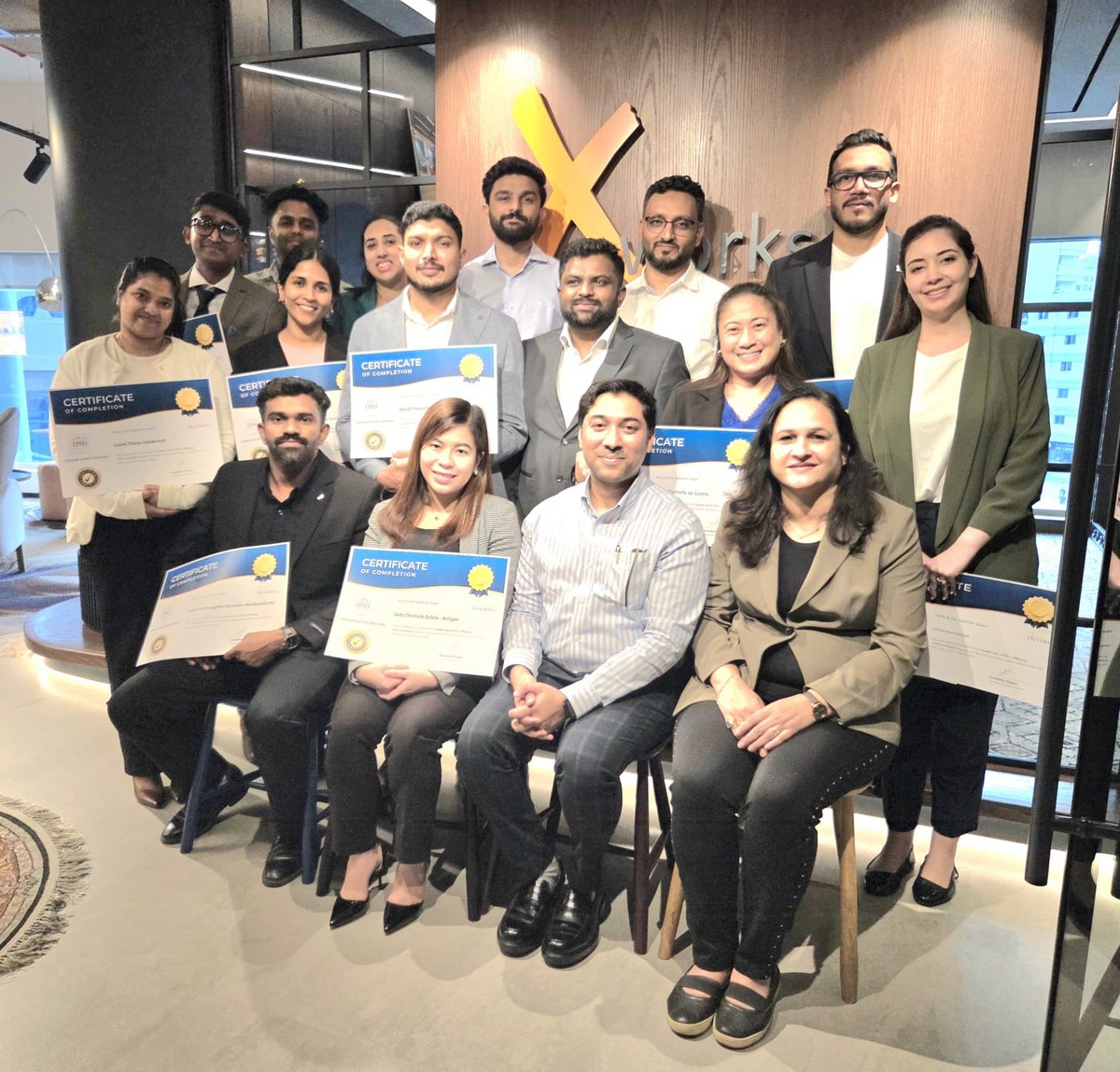 Training cohort holding certificates of completion after a corporate program